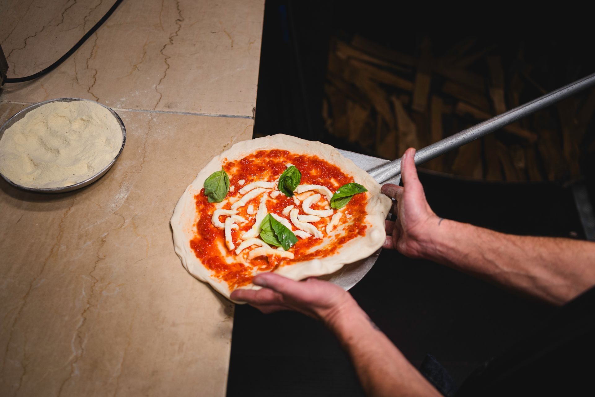 Il pizzaiolo di Fabbrica sforna una pizza margherita con la pala
