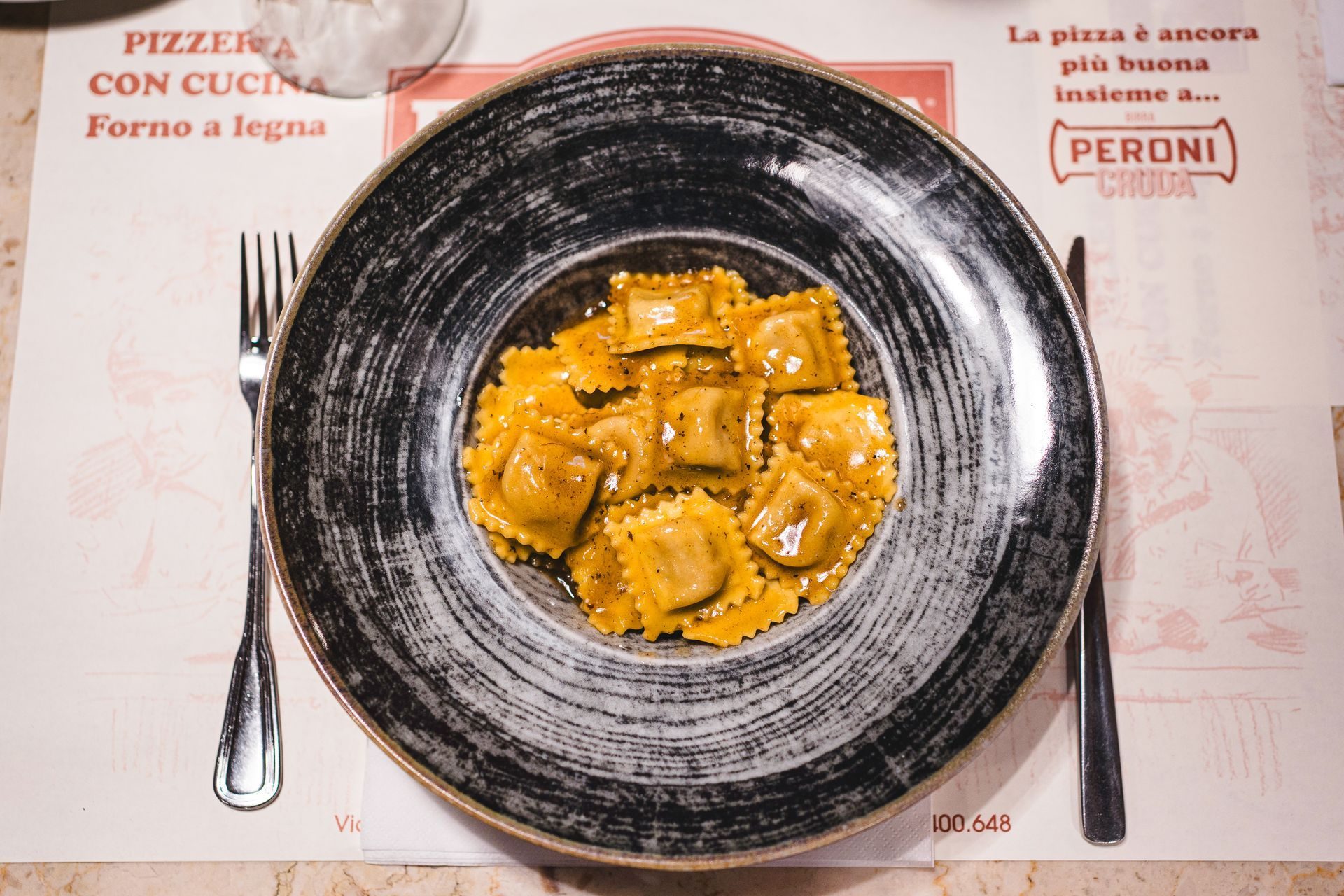 Ravioli fritti dorati sul piatto nero