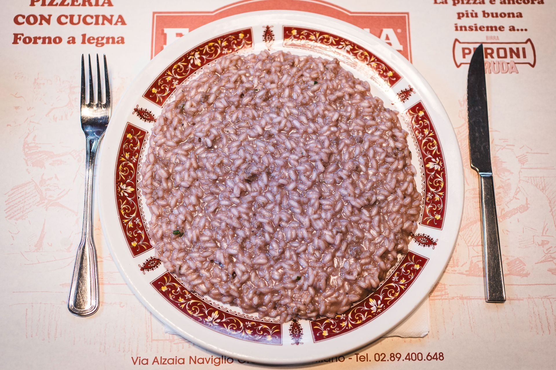 Risotto al Barbera servito sul piatto nero di Fabbrica